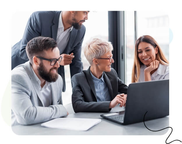 A diverse group of professionals collaborating on a laptop in a modern office setting.