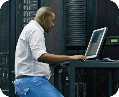 Server technician sitting at a workstation reviewing ecommerce hosting performance