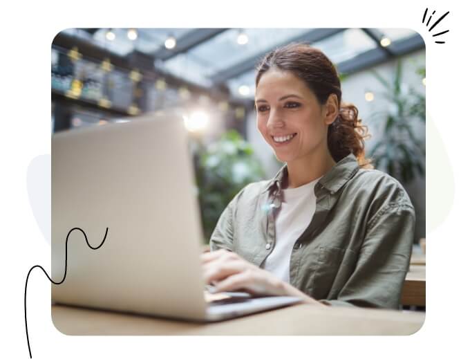 A happy woman looking at her laptop.