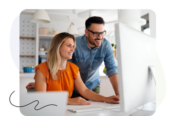 A man and woman collaborating on a laptop.