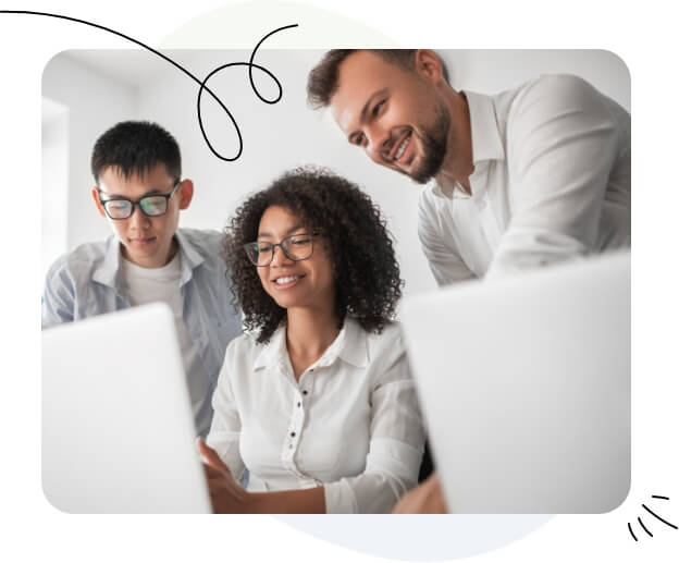 Three individuals gathered around a laptop screen.