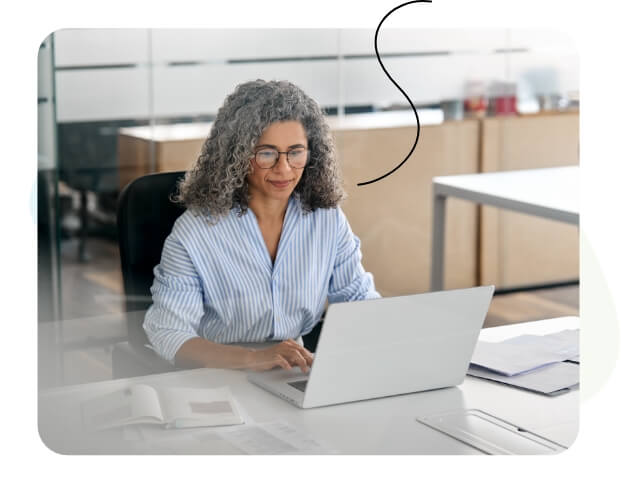 A happy woman looking at her laptop.