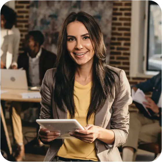 Entrepreneur working on a tablet while smiling at the camera