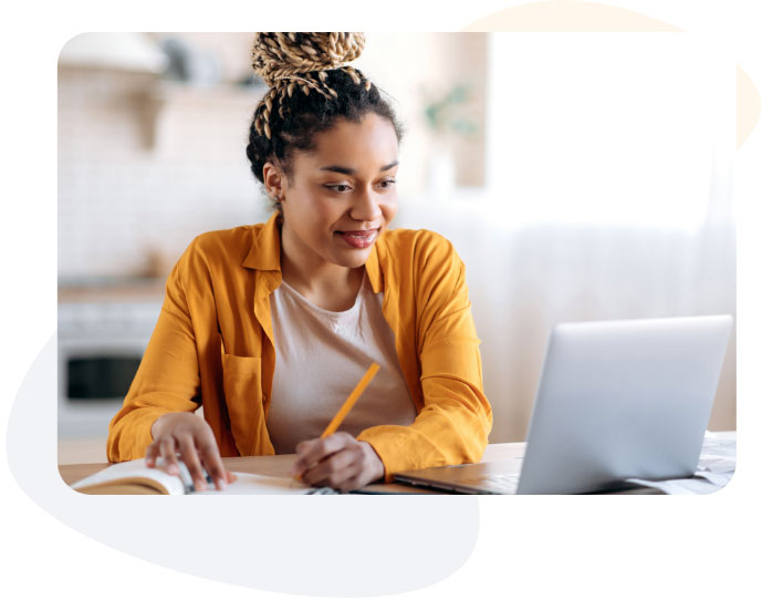 A woman focused on her laptop, typing diligently.