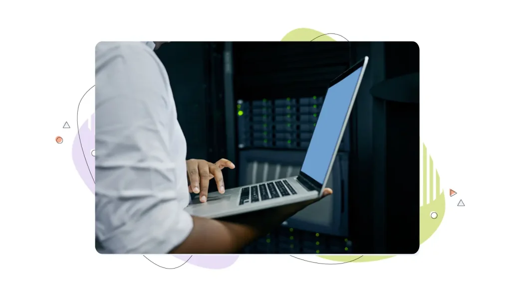 Person working on a laptop in a server room