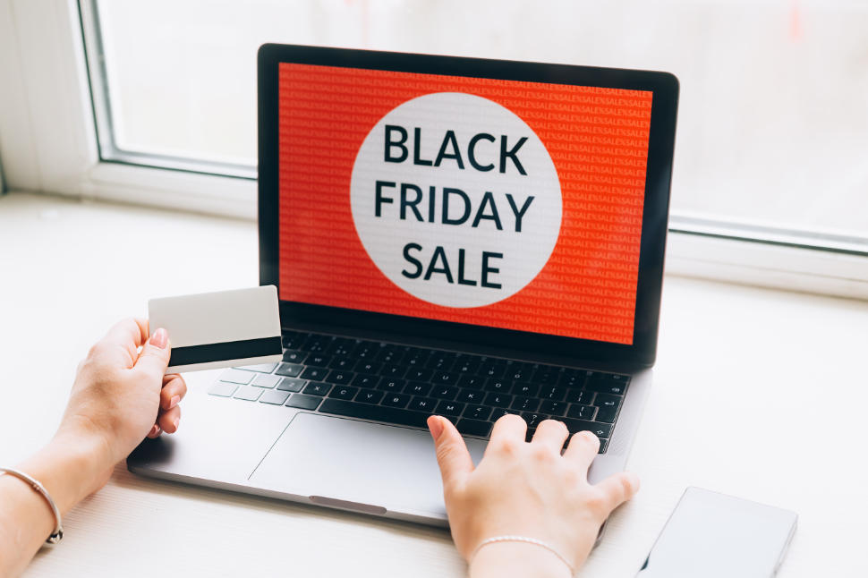 online shopping concept. Close-up top view of a wman with black friday offers on laptop. all screen graphics are made up.