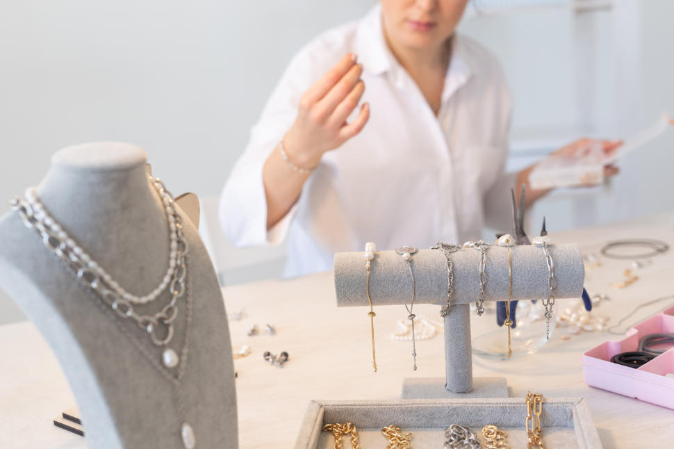 Professional jewelry designer making handmade jewelry in studio workshop. Fashion, creativity and handmade concept.