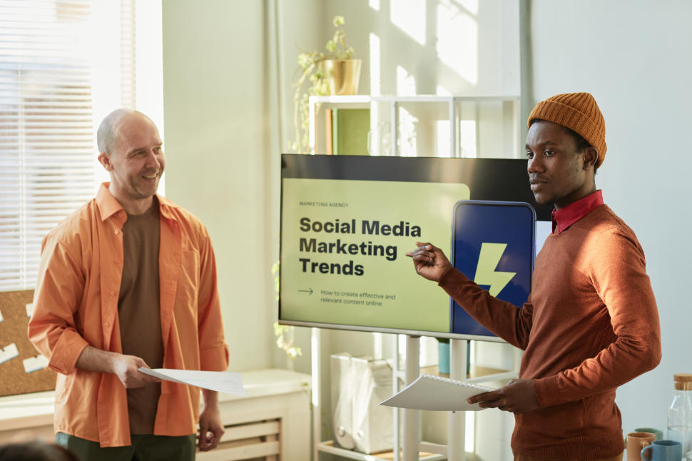 Portrait of creative black man presenting Social media marketing trends for business team in office
