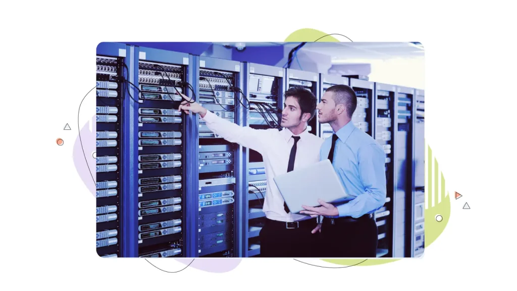 Two office workers pointing to a server