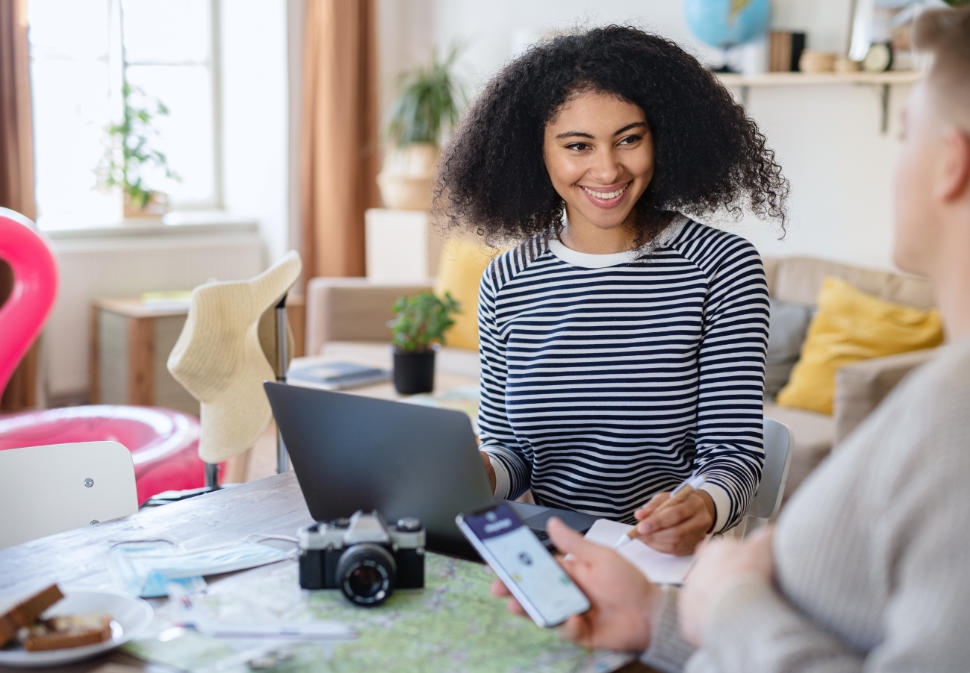 Happy young couple with laptop packing for holiday, coronavirus concept.