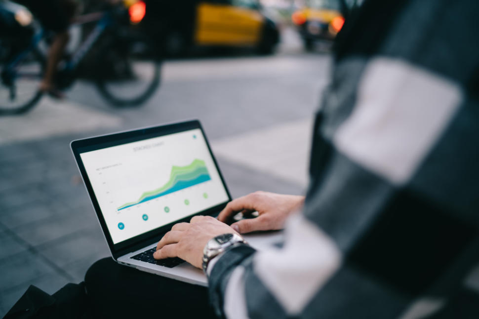 Cropped image of male student checking infographic on web pages learning during free time online outdoors, skilled man digital nomad checking exchange market news via laptop computer on remote job