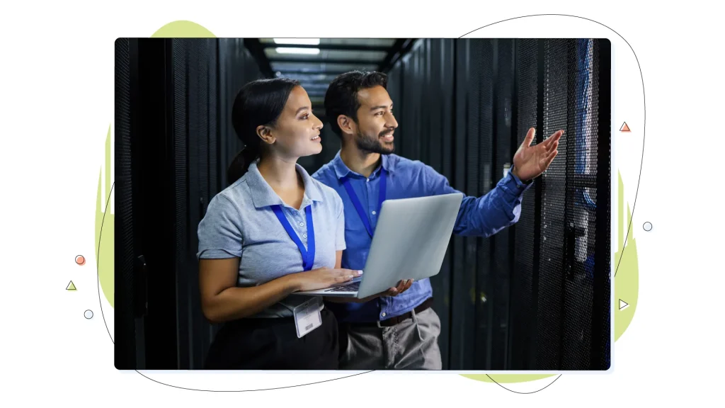 Two people in a web hosting server room with a laptop