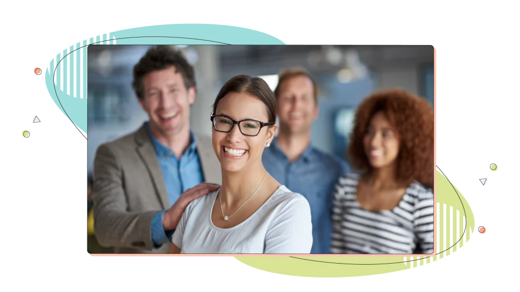 Business woman with her colleagues in the background, smiling.