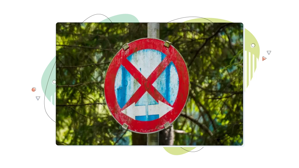 Weathered no entry road sign with trees in the background.