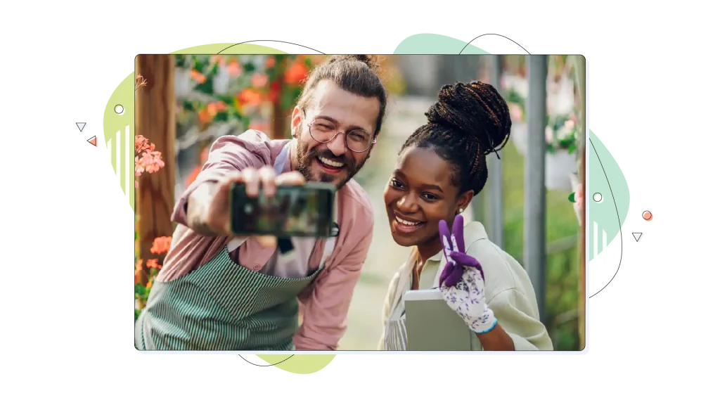 Gardener couple working in a greenhouse and taking selfie with a smartphone.