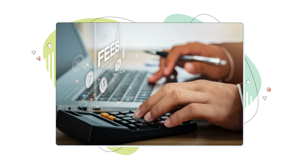 The word "fees" floating above a laptop keyboard from a person typing on it.