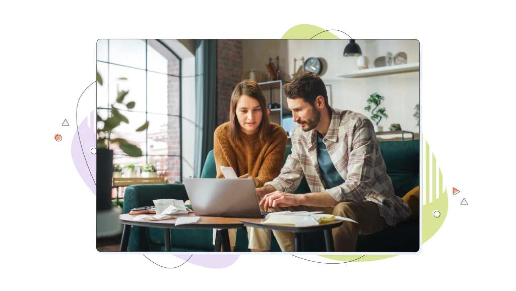 Couple working on their living room, looking at their laptop.