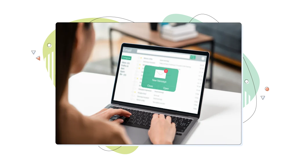 Person typing on a laptop and receiving a popup alert for a new email.