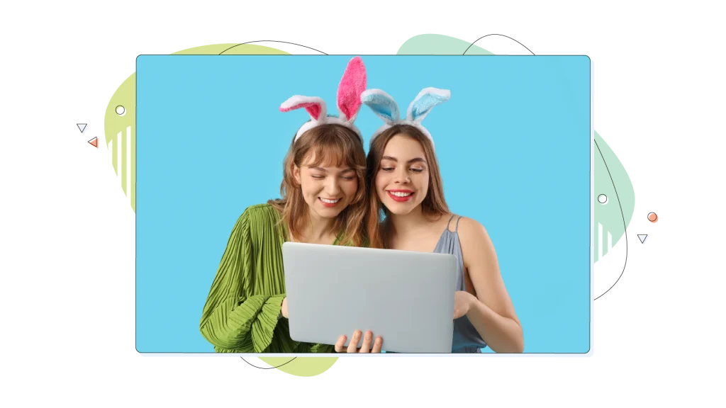 Two girls with bunny ears dressed for Easter while shopping on their laptop.