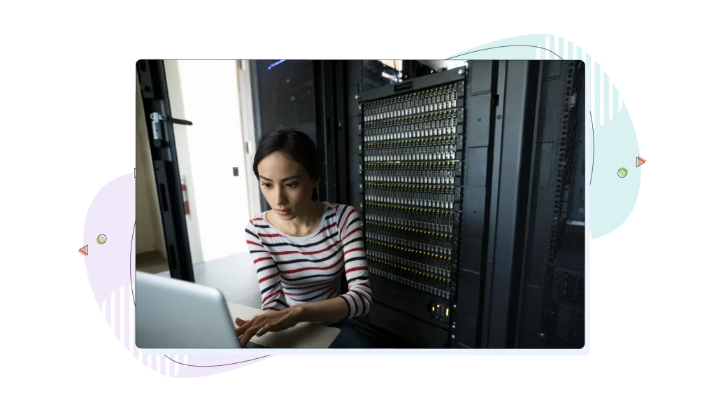 Woman working on her laptop inside a dedicated hosting server room.