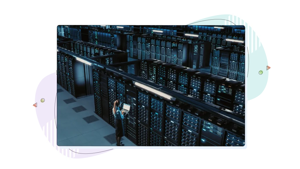 A room full of servers in a room with a person working on their laptop.