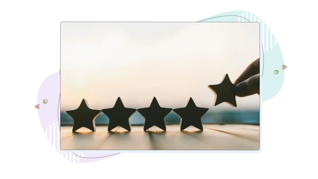 Five stars made of wood are being placed on a wooden surface by a person.