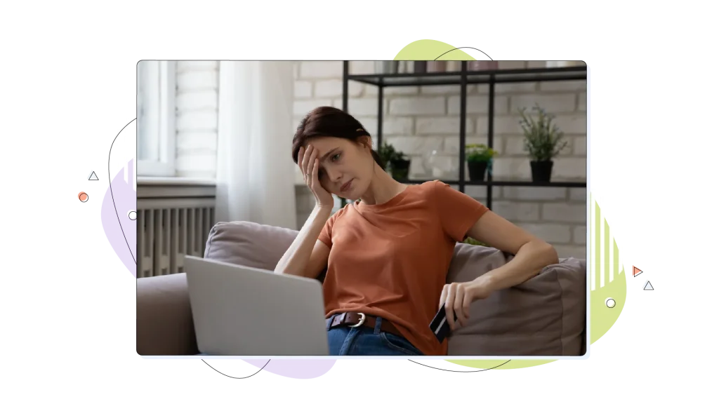Woman frustrated, looking over at her laptop.
