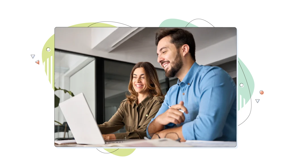 Business people smiling over their laptop, hitting their business targets.