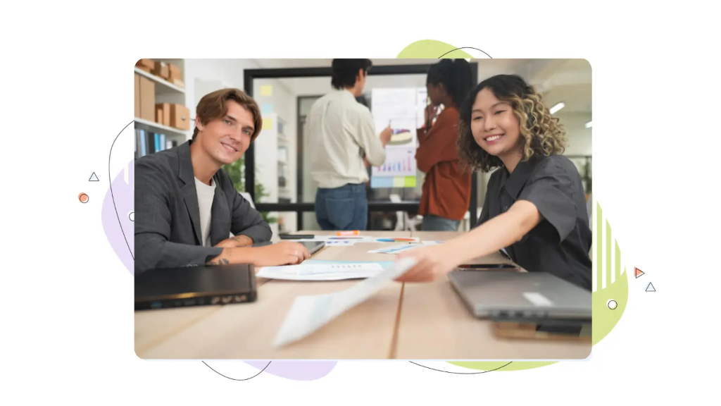Two office colleagues are handing a paper contract to a potential customer, emphasizing the risk that small business-data breaches pose to customer information in everyday agreements.