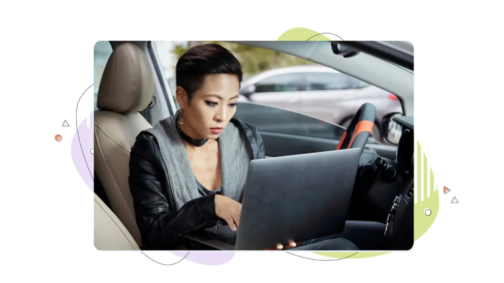 A woman sitting in her car looking at a laptop to check domain value.