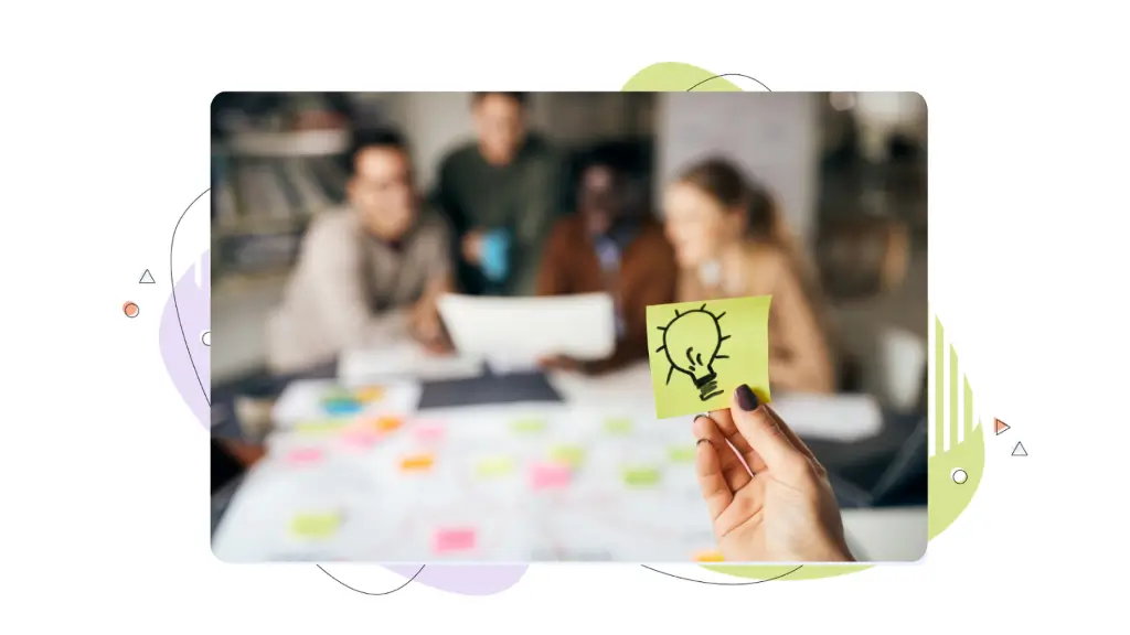 Someone looks at a piece of yellow notepaper which has a drawing of a lightbulb on it while wondering if premium domains are worth it. In the background, a marketing team is having a meeting.