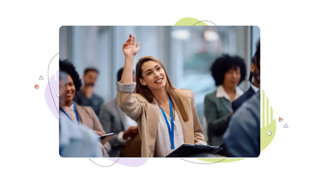 A young businesswoman raises her hand to ask a question about professional email format at a conference.