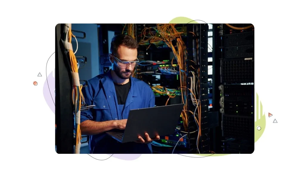 Technician working on a web server rack with his laptop.