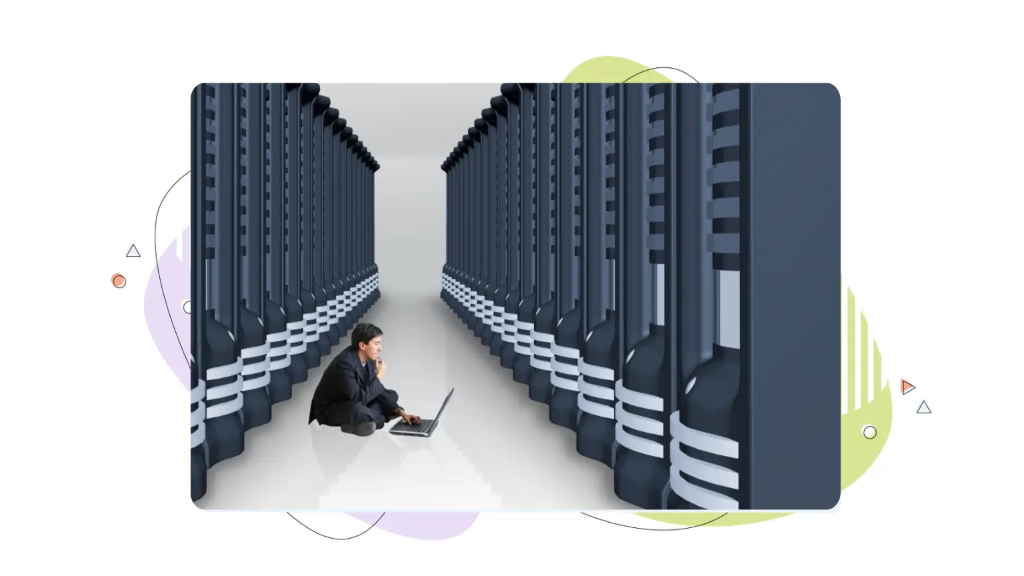 IT professional sitting on the floor with a laptop inside a server room, learning how to choose a VPS hosting provider.