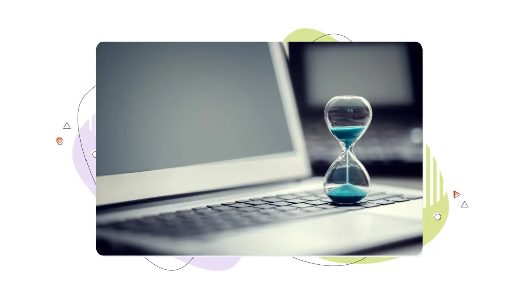 An hourglass with blue sand resting on a laptop keyboard, representing web performance and VPS hosting speed.