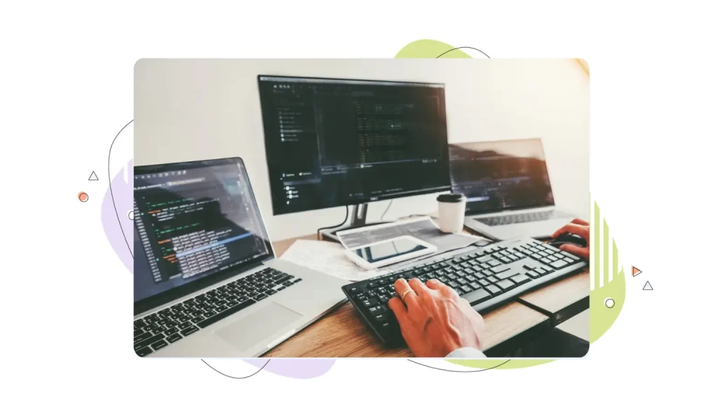 Person working on multiple computer monitors
