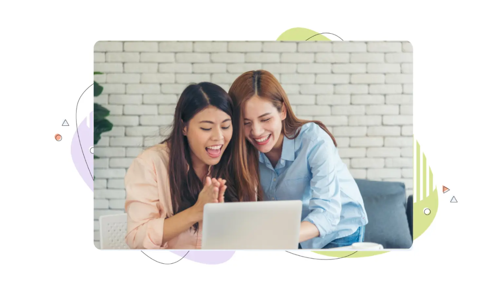 Two happy women celebrating in front of a laptop after completing a wordpress vps setup.